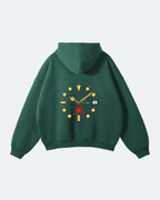 Green Oman Edition Hoodie with a unique design on the back against a light gray background