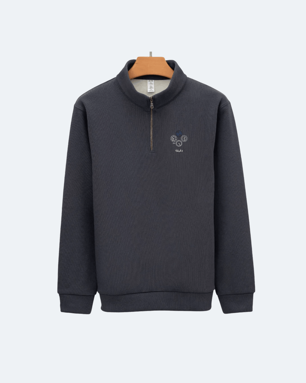 Dark gray Perpetual Flight Quarter Zip sweatshirt with a small logo on a light gray background