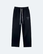 Black Perpetual Flight Trackpants with a small logo on a white background