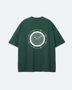 Green Royal Time T-Shirt with a white geometric design on the back against a light blue background